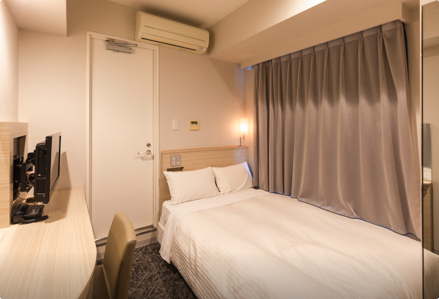 The EXPRESS Single at Sotetsu Fresa Inn Tokyo-Kyobashi: a 120 cm bed beside a curtained window, a desk with a TV on the left, and a narrow strip of floor to the door.